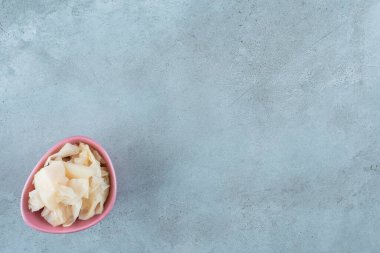 Mavi arka planda plastik bir kasede havuçlu mayalanmış lahana turşusu. Yüksek kalite fotoğraf