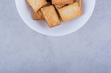 Taş zeminde beyaz bir tabak lezzetli çıtır kraker. Yüksek kalite fotoğraf