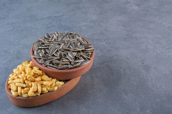 葵花籽和饼干鱼在一个粘土碗里 大理石背景 高质量的照片 — 图库照片