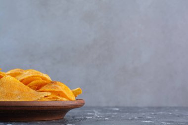 Tabakta patates cipsi var, mermer arka planda. Yüksek kalite fotoğraf