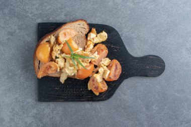 Domatesli yağda yumurta ve kara tahtada ekmek. Yüksek kalite fotoğraf