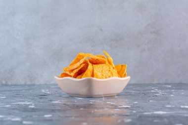 Bir kase lezzetli patates cipsi, mermer arka planda. Yüksek kalite fotoğraf