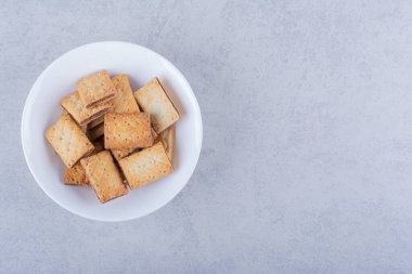 Taş zeminde beyaz bir tabak lezzetli çıtır kraker. Yüksek kalite fotoğraf