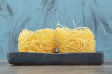 Siyah tabakta pişmemiş iki erişte yuvası. Yüksek kalite fotoğraf