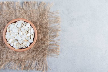 Taş zeminde seramik bir kap çiğ kabak çekirdeği. Yüksek kalite fotoğraf