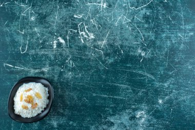 Mavi arka planda, bir kase sütlaca kuru üzüm. Yüksek kalite fotoğraf