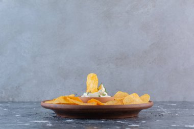 Yoğurt ve patates cipsi tabakta, mermer arka planda. Yüksek kalite fotoğraf