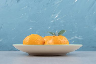 Yeşil tabakta yaprakları olan taze mandalina. Yüksek kalite fotoğraf