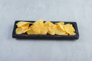 Siyah tabakta çıtır çıtır lezzetli cips yığını. Yüksek kalite fotoğraf