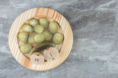 Dilimlenmiş turşuların üst görüntüsü gri arka planda tahta tabakta. Yüksek kalite fotoğraf