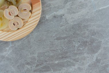 Gri arka planda tahta tabakta küçük elma turşusu. Yüksek kalite fotoğraf