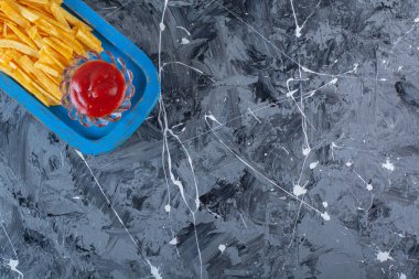 Ketçap ve patates kızartması ahşap bir tabakta, mermer arka planda. Yüksek kalite fotoğraf