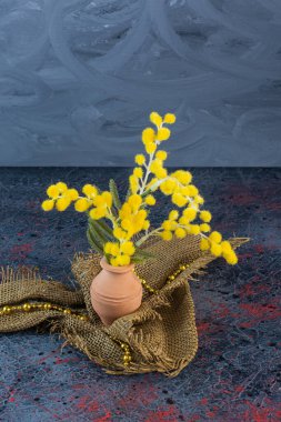 Sarı çiçekli, sarı kolyeli bir kil sürahi. Yüksek kalite fotoğraf