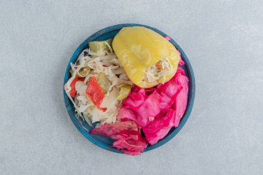 Tatlı biber, doğranmış yeşil ve kırmızı lahana turşusu bir kasede, mermer arka planda. Yüksek kalite fotoğraf