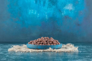 Çuval bezinde bir tabak mısır topu, mavi arka planda. Yüksek kalite fotoğraf