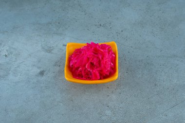 Mavi arka planda bir kase kırmızı lahana turşusu. Yüksek kalite fotoğraf