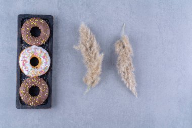 Renkli şekerli üç tane çikolatalı çörek. Yüksek kalite fotoğraf