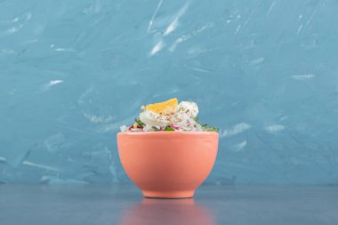 Lezzetli haşlanmış yumurta ve turuncu kasede taze salata. Yüksek kalite fotoğraf