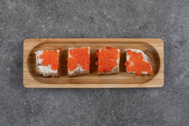 Gri arka planda kırmızı havyarlı taze sandviçin üst görüntüsü. Yüksek kalite fotoğraf