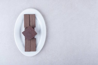 Çikolata kaplı gofretler bir tabakta, mermer arka planda. Yüksek kalite fotoğraf