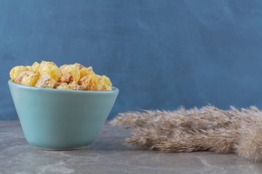 Gri arka planda mavi bir tabak sağlıklı mısır gevreği. Yüksek kalite fotoğraf