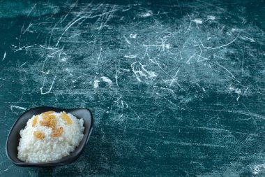 Mavi arka planda, bir kase sütlaca kuru üzüm. Yüksek kalite fotoğraf