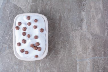 Kahvaltıda sağlıklı yoğurt ve küçük çikolata topları olan beyaz bir tahta. Yüksek kalite fotoğraf