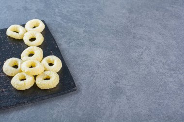 Kesme tahtasındaki mısır halkaları, mermer arka planda. Yüksek kalite fotoğraf