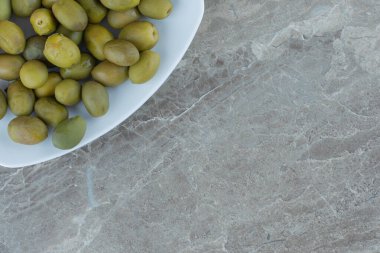 Beyaz tabakta marine edilmiş yeşil zeytin manzarası. Yüksek kalite fotoğraf