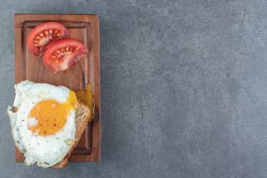 Tahtada kızarmış yumurta ve domatesli tost ekmeği. Yüksek kalite fotoğraf