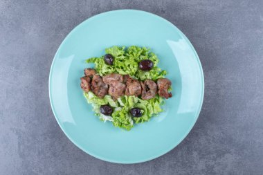 Mavi tabakta ciğer kebabı ve zeytin. Yüksek kalite fotoğraf