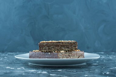 Tatlı çikolata kaplı waffle tabakta, mavi arka planda. Yüksek kalite fotoğraf