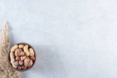 Taş zeminde çeşitli kabuklu cevizlerle dolu ahşap bir kase. Yüksek kalite fotoğraf