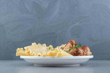 Beyaz tabakta kızarmış tavuk ve makarna. Yüksek kalite fotoğraf