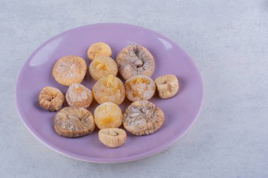 Mor tabağa konmuş bir demet kurutulmuş incir. Yüksek kalite fotoğraf