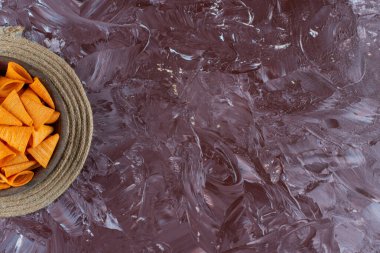 Mermer arka planda, trivet kasesindeki koni cipsleri. Yüksek kalite fotoğraf