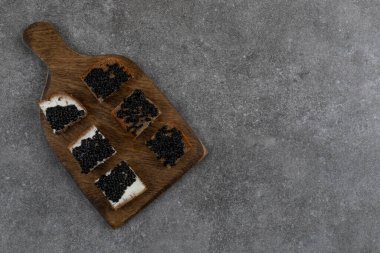 Sandviç, ekmek ve siyah havyar. Tahta kesme tahtasının üzerinde. Yüksek kalite fotoğraf