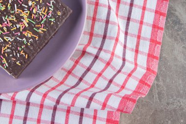 Tahtadaki çikolatalı waffle 'ın üzerine şeker serpilmiş, mermer arka planda. Yüksek kalite fotoğraf