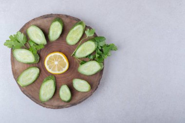Mermer zemin üzerinde taze, dilimlenmiş salatalık, limon ve maydanoz. Yüksek kalite fotoğraf