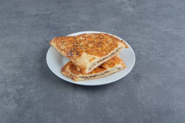 Beyaz tabakta etle doldurulmuş üçgen şekilli hamur işleri. Yüksek kalite fotoğraf