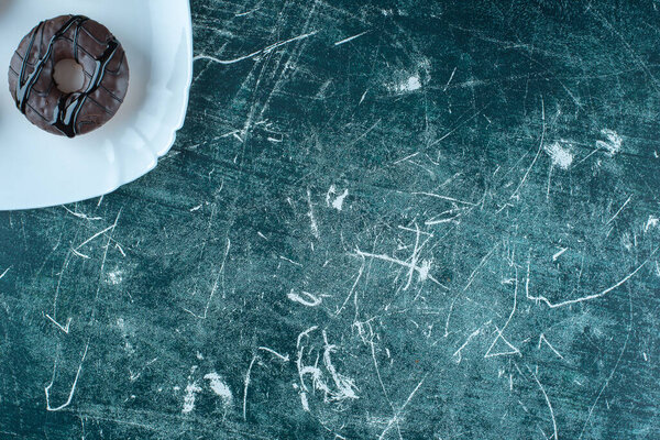 Chocolate coated cookies and donuts on a plate , on the blue background. High quality photo