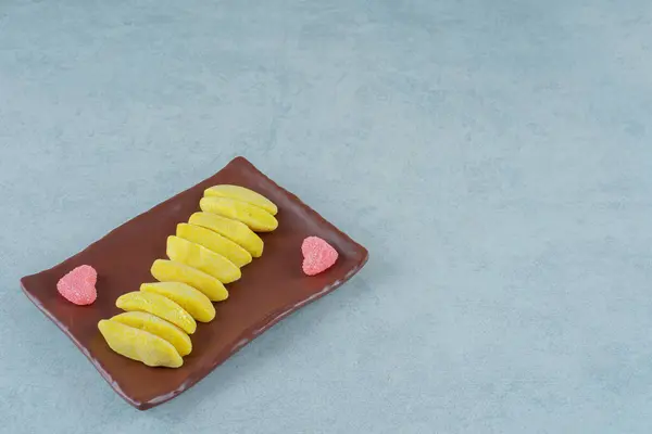 バナナの茶色のプレートは ハート型の砂糖マーマレードとキャンディを噛む形 高品質の写真 — ストック写真