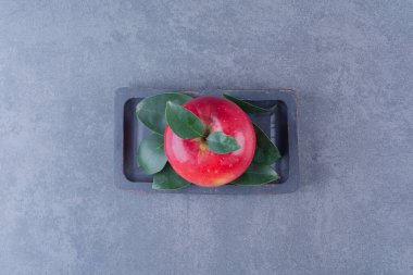 Ahşap bir tabakta, mermer zeminde bir elma gösterisi. Yüksek kalite fotoğraf