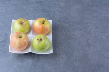 Mermer arka planda, tabakta taze elmalar. Yüksek kalite fotoğraf