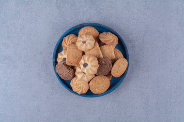 Çuval bezinde tatlı, yuvarlak, lezzetli kurabiyeler olan mavi tahta bir tahta. Yüksek kalite fotoğraf