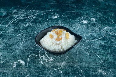 Mavi arka planda, bir kase sütlaca kuru üzüm. Yüksek kalite fotoğraf