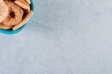 Mermer zemin üzerinde sağlıklı kurutulmuş meyvelerle dolu mavi bir tabak. Yüksek kalite fotoğraf