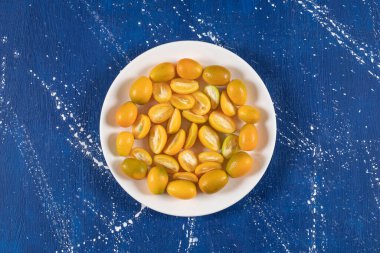 Dilimlenmiş beyaz tabak taze kumkatlı meyveler mermer arka planda. Yüksek kalite fotoğraf