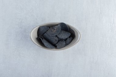 Gri kase taştan arka planda çıtır siyah cips. Yüksek kalite fotoğraf