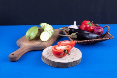 Mavi arka planda dilimlenmiş kabaklı sepet dolusu taze sebze. Yüksek kalite fotoğraf